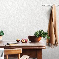 Vintage interior design of kitchen space with small table against white wall with simple chairs and vegetables. Minimalistic concept of kitchen space.