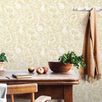 Vintage interior design of kitchen space with small table against white wall with simple chairs and vegetables. Minimalistic concept of kitchen space.